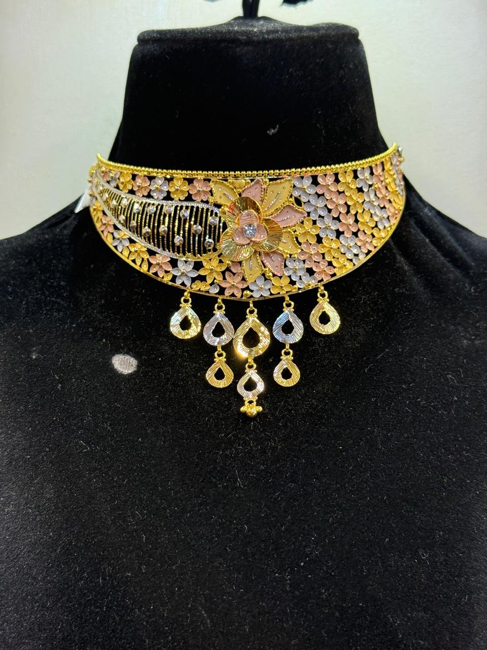 A gold choker with a peacock-inspired fan design