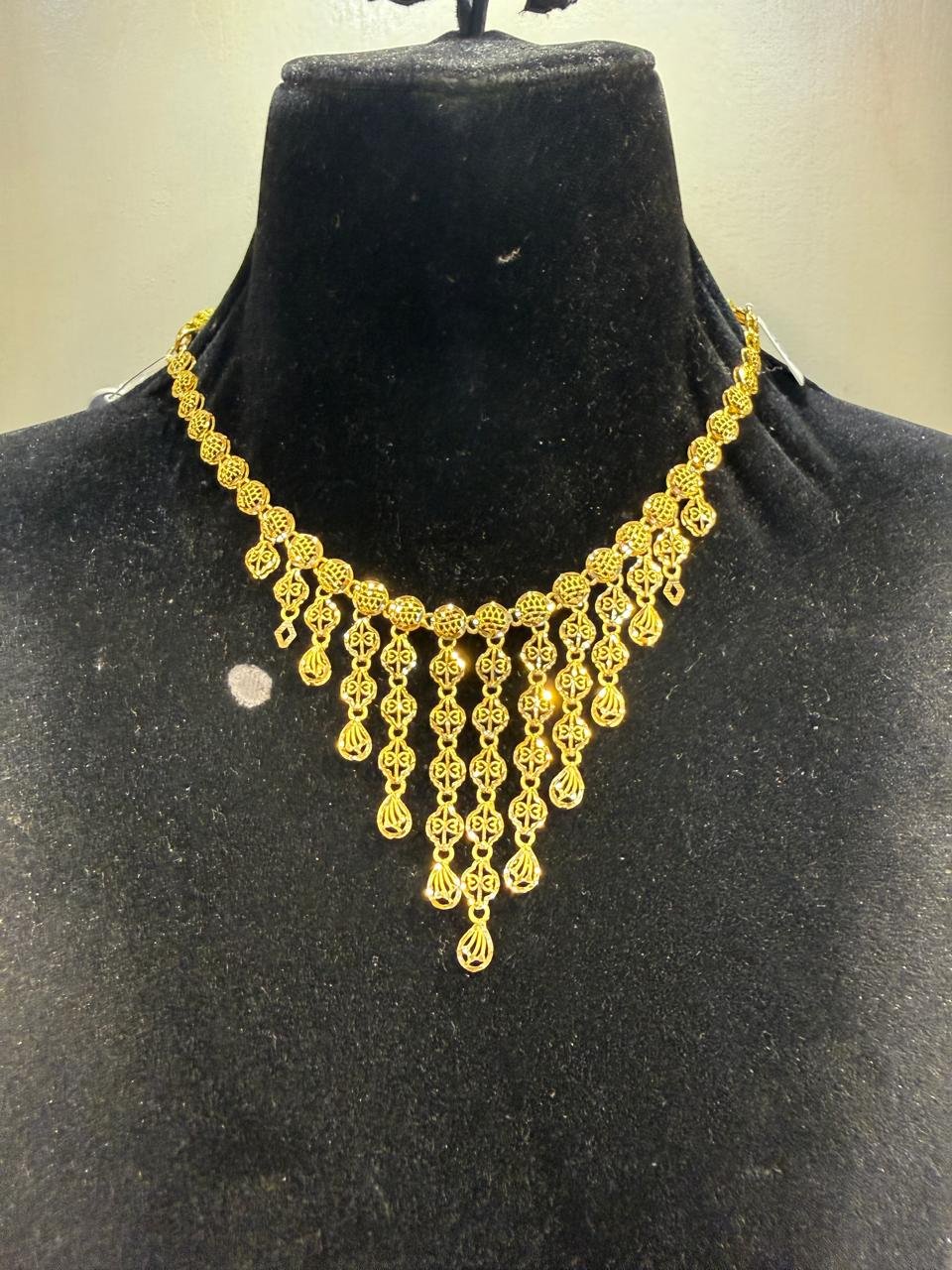 A gold necklace with a ball-chain and bead-drop fringe