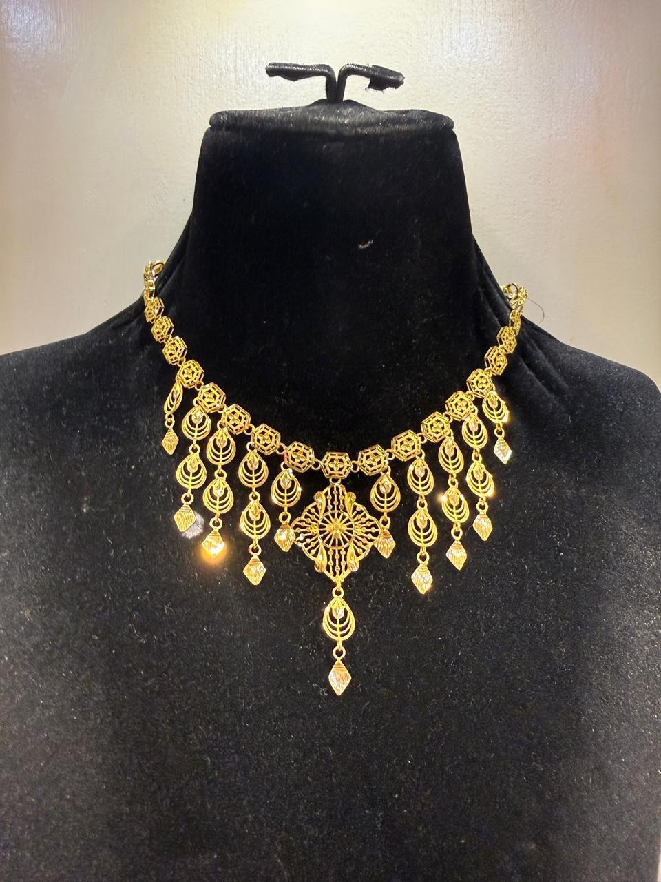 A gold necklace with a beaded chain and drop tassels
