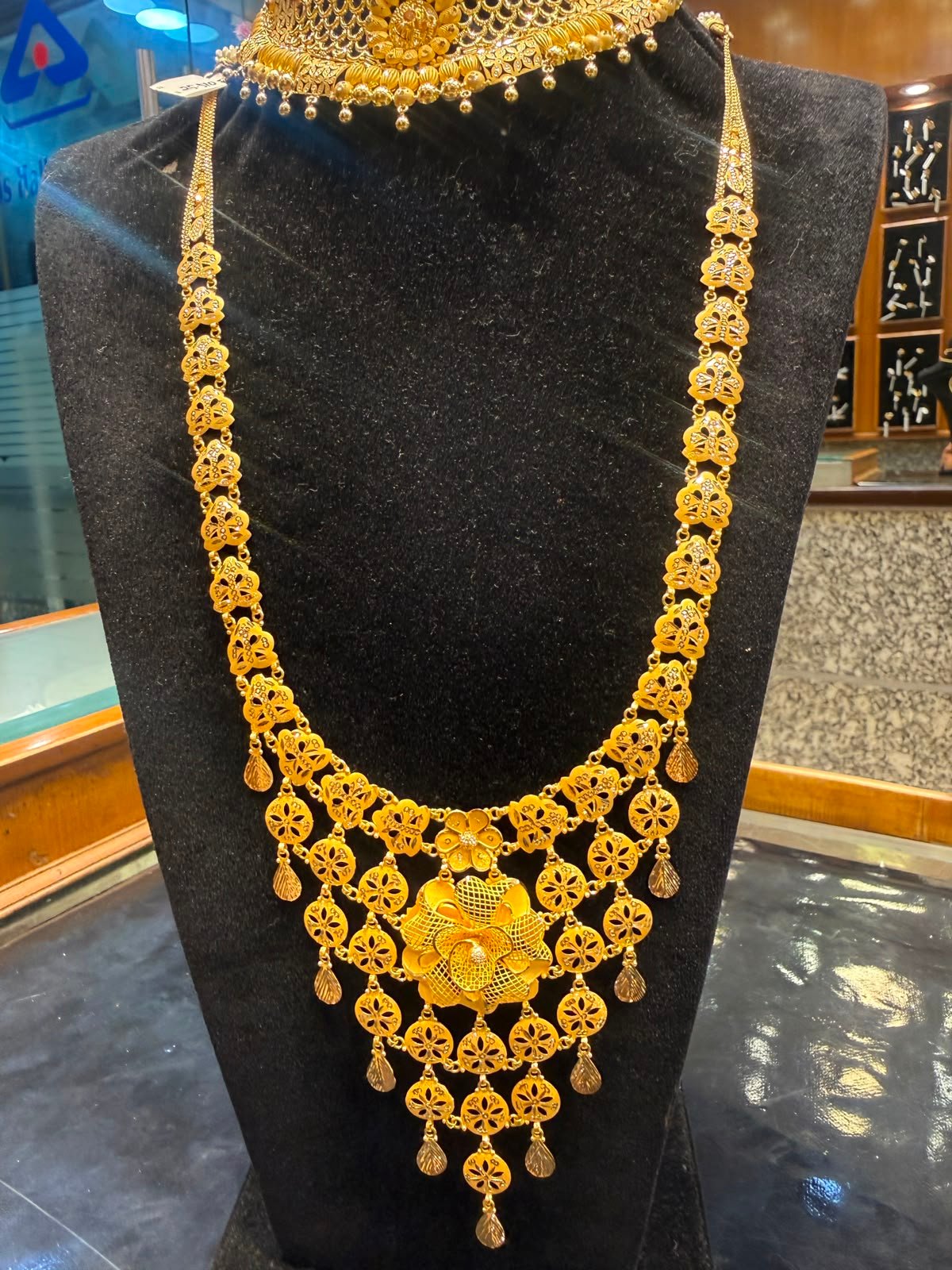 A long gold necklace with jhumka-style drops and a central pendant