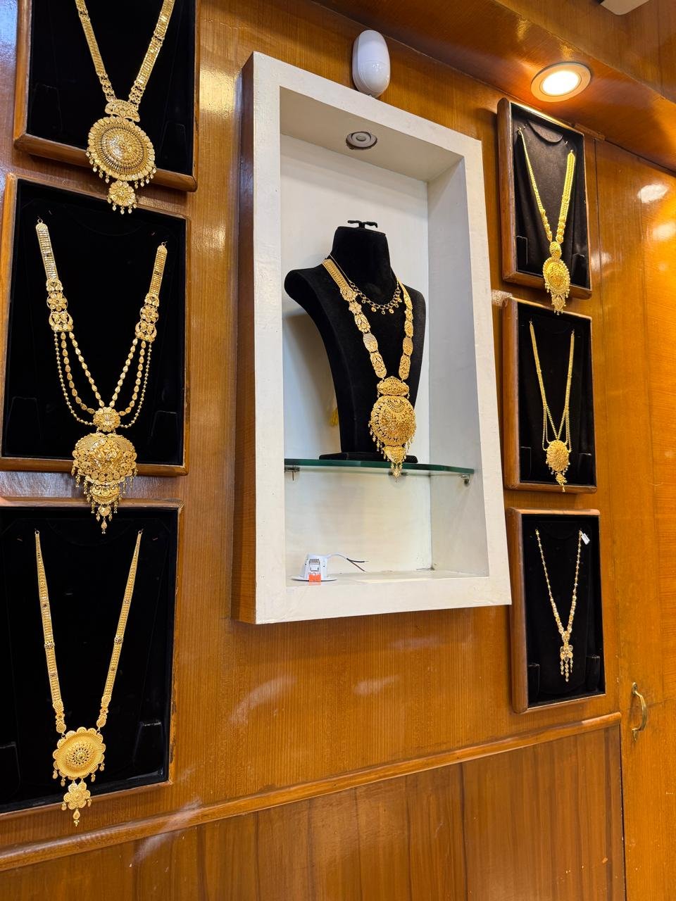 Wall-mounted necklace displays inside the Aina Gold showroom